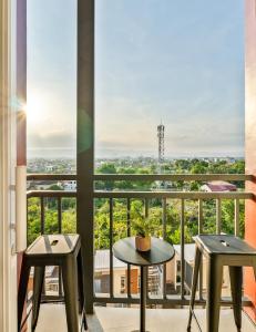 a balcony with two tables and two stools at Lumiere Prime Studio - Mactan Pool Escape in Pajak