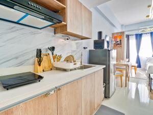 a kitchen with a sink and a refrigerator at Lumiere Prime Studio - Mactan Pool Escape in Pajak