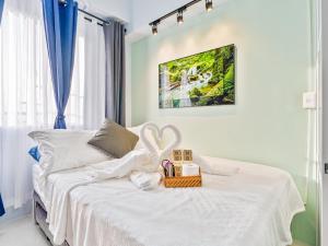 a bedroom with a white bed with a basket on it at Lumiere Prime Studio - Mactan Pool Escape in Pajak