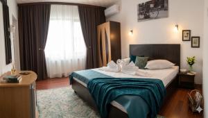 a hotel room with a large bed and a window at Vila Roxy Costinesti in Schitul