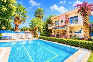 a villa with a swimming pool in front of a house at Villa Garden Island in Dalyan