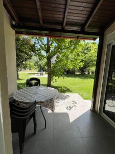 a table and chairs sitting on a patio with a view of a park at Priona Rooms in Paralía Skotínis