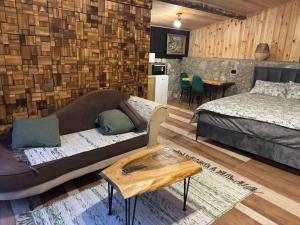 a bedroom with a couch and a bed and a table at Ethno House Bektesevic in Gusinje