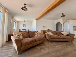 a living room with two couches and a kitchen at Casa Joanna Lanzarote in Nazaret