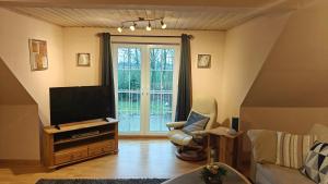 a living room with a flat screen tv and a couch at Fewo Skjærnsøde in Fjerritslev