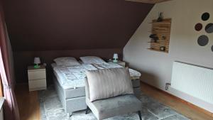 a bedroom with a bed and a chair at Fewo Skjærnsøde in Fjerritslev +26 photos