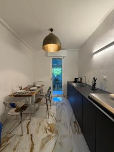 a kitchen with a marble floor with a table and a sink at Effealatapartments - L'Oasi del Forte in Forte dei Marmi