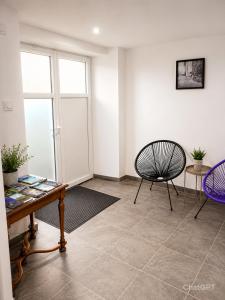 a living room with a table and a chair at Le pat' toit in Aurec-sur-Loire