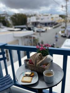 a table with a basket of bread and cups of coffee at Gemelos Cozy Stay in Megali Ammos