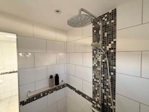 a bathroom with a shower with black and white tiles at Casa Joanna Lanzarote in Nazaret +18 photos