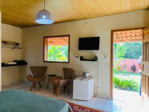a bedroom with a bed and a tv and a window at Veraneio Recanto dos Ipês in Pirenópolis
