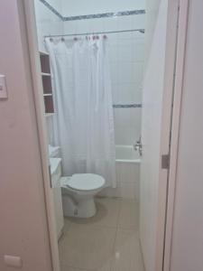 a bathroom with a toilet and a shower curtain at casa completa e independiente en 2 piso in Antofagasta