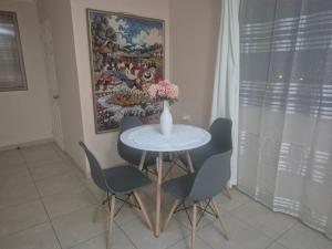 a dining room table with chairs and a vase with flowers at casa completa e independiente en 2 piso in Antofagasta +8 photos