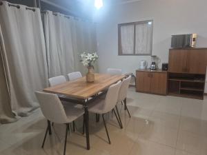 a dining room with a wooden table and white chairs at casa completa e independiente en 2 piso in Antofagasta