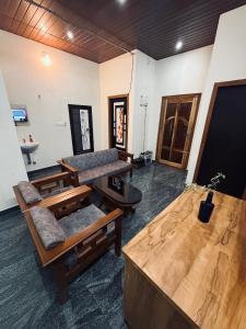 a living room with wooden furniture and a flat screen tv at Palm paradise in Kadavoor