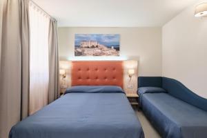 a bedroom with two beds and a couch at Albergo Della Posta in Bracciano