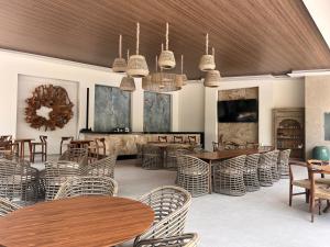 a restaurant with wooden tables and rattan chairs at Hotel Boutique Casa Ceibas in Cuautla Morelos