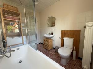 ein Badezimmer mit Badewanne, Toilette und Waschbecken in der Unterkunft Murmelruh in Mittenwald + 11 Fotos
