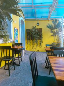 a restaurant with tables and chairs and a yellow wall at Center 1 Hotel in Fortaleza