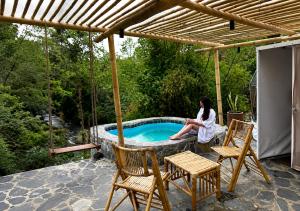 a woman sitting on a swing by a swimming pool at Alma Glamping in Xalapa