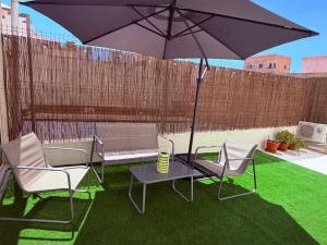 a patio with a table and chairs and an umbrella at LOFT La Palma in Almería