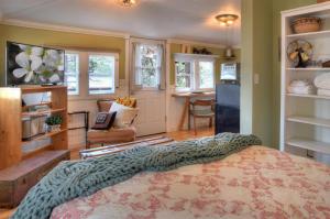a bedroom with a bed and a kitchen at Red Bungalow Vallecito Studio Cabin near Durango, CO in Bayfield