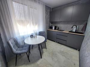 a small kitchen with a table and chairs and a window at Премиум квартира в современном стиле in Līsakovsk