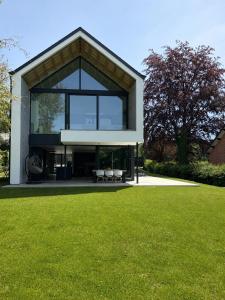 a house with a large window on a lawn at Maison Unifamiliale in Theux