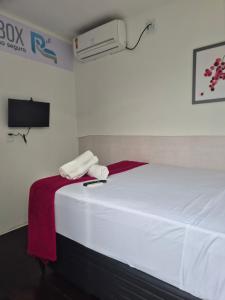 a bedroom with a bed with two towels and a air conditioner at Repouso Box in Cabo de Santo Agostinho +8 photos
