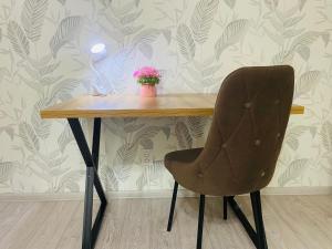 a wooden table with a chair and a plant on it at Comfort Home Gogolya in Karagandy +3 photos