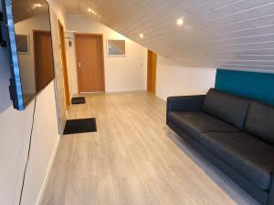 a living room with a couch and wooden floors at Ferienwohnung am Soonwald in Ellern
