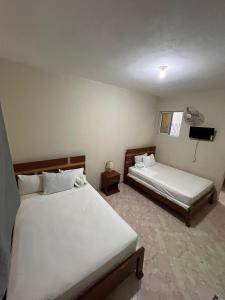 a bedroom with two beds and a television in it at Darlouis hotel cap Haitien in Au Bery +12 photos