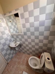 a bathroom with a toilet and a sink at Darlouis hotel cap Haitien in Au Bery