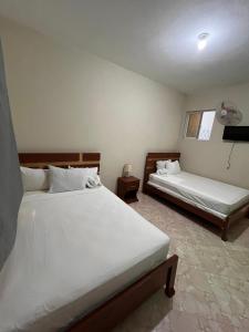 a bedroom with two beds and a window at Darlouis hotel cap Haitien in Au Bery