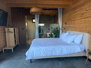 a bedroom with a bed with a wooden wall at Rosa Carmel in Dāliyat el Karmil