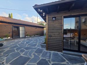a house with a stone patio next to a building at Rosa Carmel in Dāliyat el Karmil
