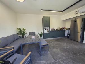 a living room with a couch and a table and a kitchen at Rosa Carmel in Dāliyat el Karmil
