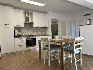 a kitchen with a wooden table and chairs and a refrigerator at Apartment, Sulina's House 2 in Campofelice di Roccella +2 photos