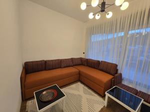 a living room with a brown couch and a window at Ski & SunDeck in Bjelašnica