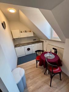 a small room with a table and chairs and a kitchen at Bright studio-flat near station - Bayreuth in Bayreuth
