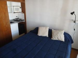 a bed in a room with a blue blanket at SL 1908 in Olivos