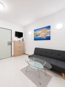 a living room with a couch and a glass table at Central Msida Modern Holiday Apartment in Tal-Ħriereb
