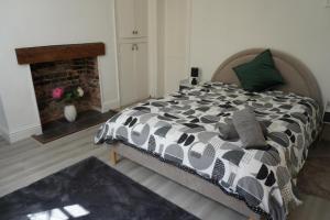 a bedroom with a large bed with a fireplace at Garden Seafront Flat Hastings in Hastings
