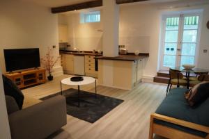 a living room with a couch and a kitchen at Garden Seafront Flat Hastings in Hastings