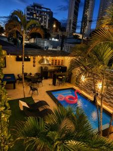 a swimming pool with a red swan in a courtyard at Pousada Jardim Mágico in Ponta Negra
