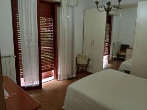 a bedroom with a bed and a room with windows at Caterina in Marina di Massa