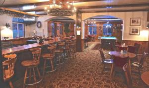 a bar with wooden stools and tables in a restaurant at Mittersill Alpine Resort in Franconia