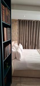 a bedroom with a bed with white pillows and a book shelf at la suite 4 de Saint Jean in Crémieu