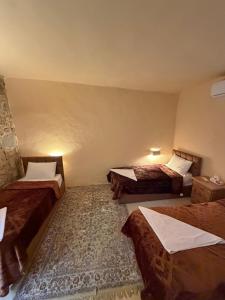 a room with three beds in a room at Mawasem Dana in Dana