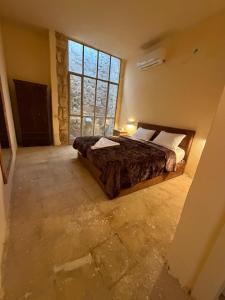 a bedroom with a bed and a large window at Mawasem Dana in Dana +5 photos